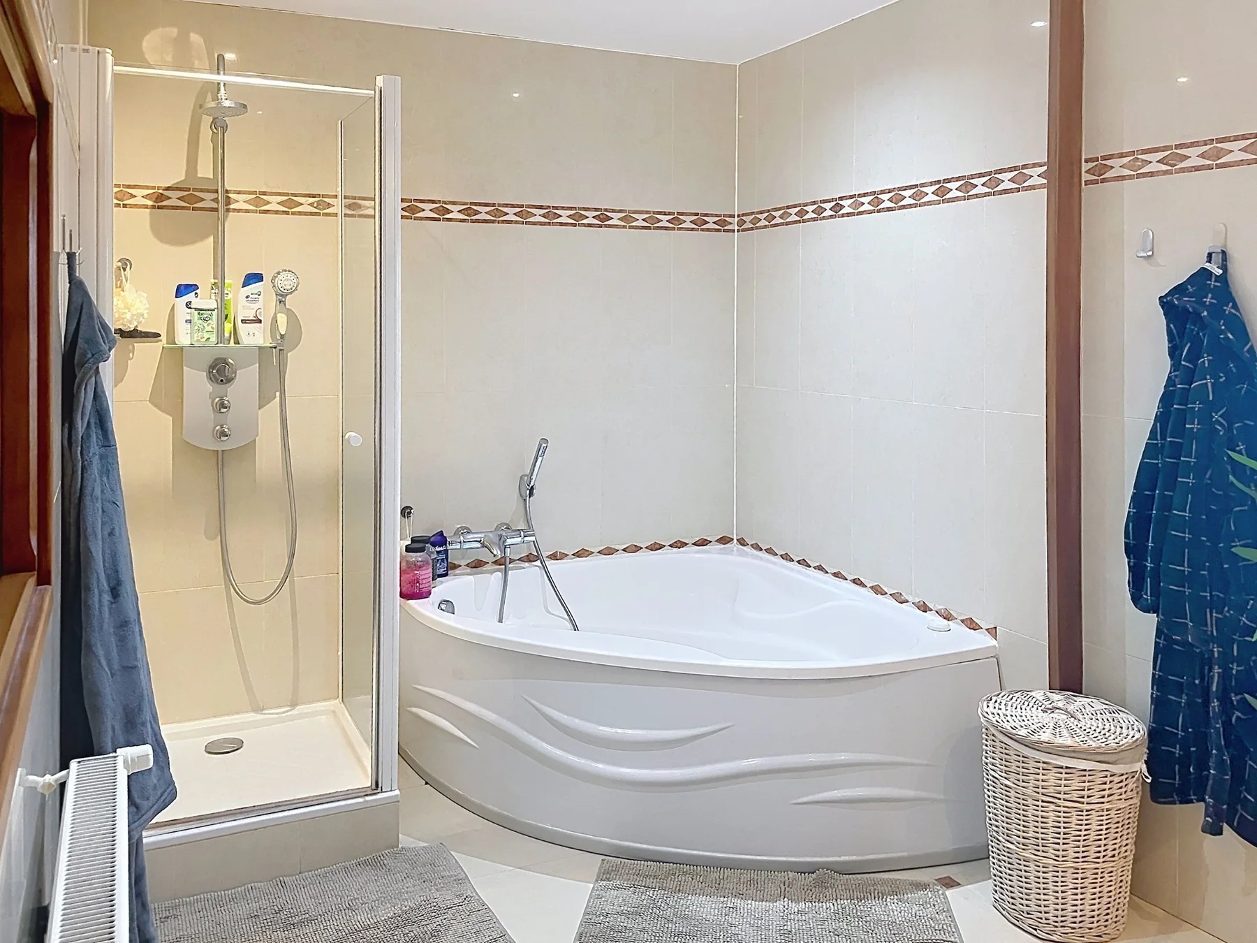 Salle de bains avec baignoire d'angle et douche